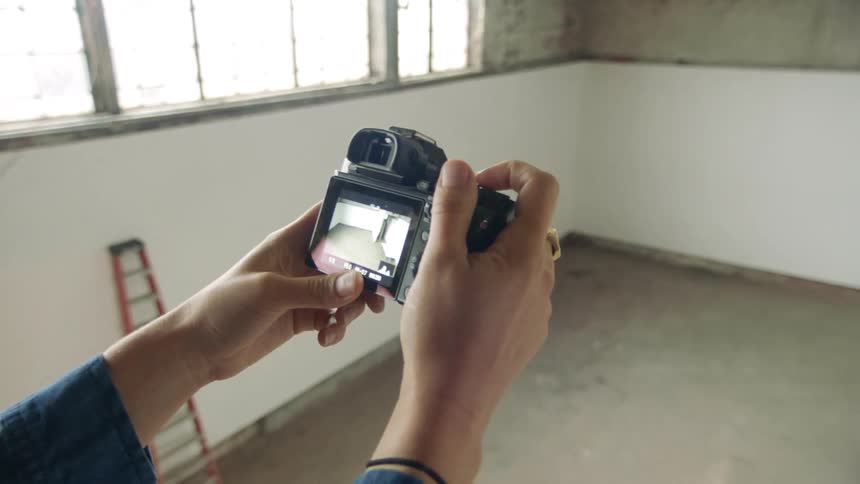 A woman takes photos in an empty room