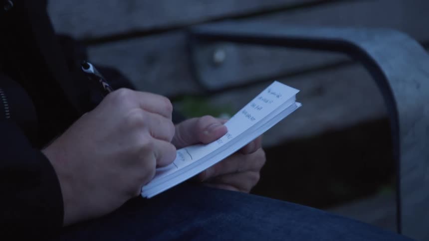 A man writes on a piece of paper