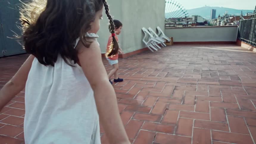 A little girl running on a rooftop