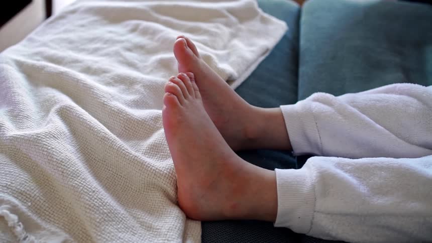 A persons feet laying in bed