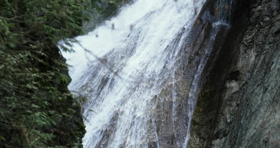 A waterfall pours down a rock face with great force