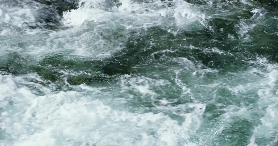 A river flows and churns causing foam and white water