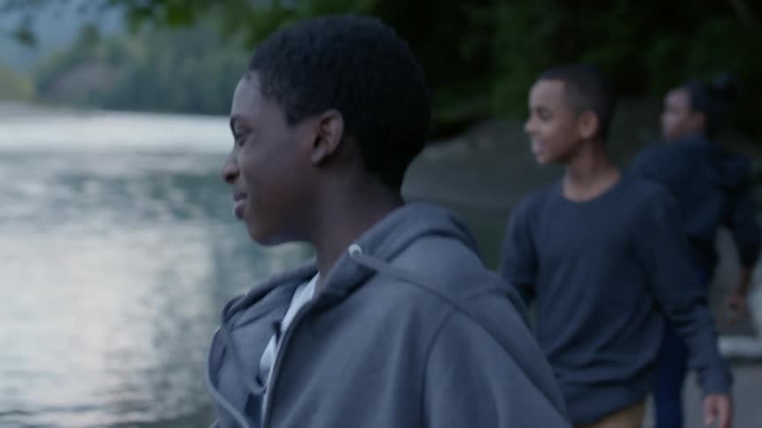 Three kids skip stones at the lake