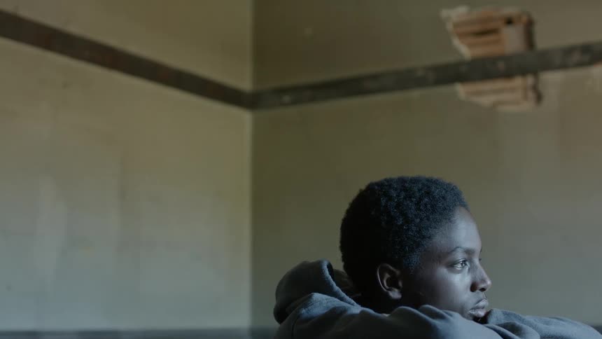 Teenager sitting inside an abandoned house
