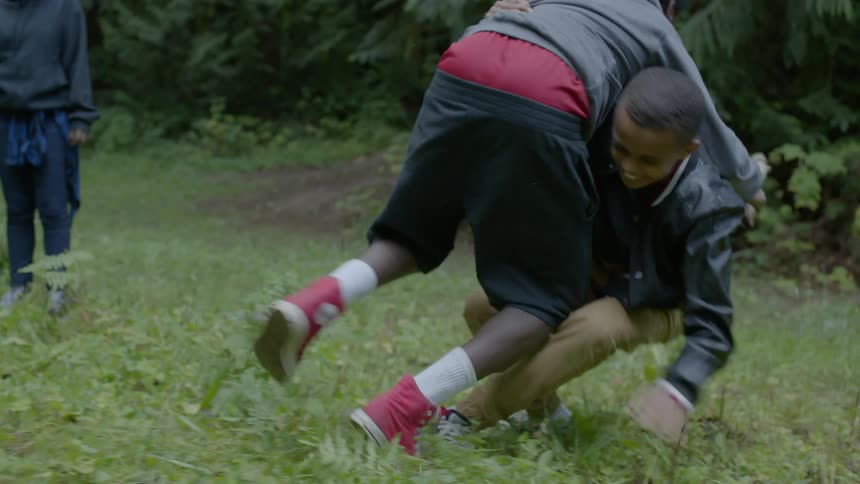 Two boys playing while a girl looks on