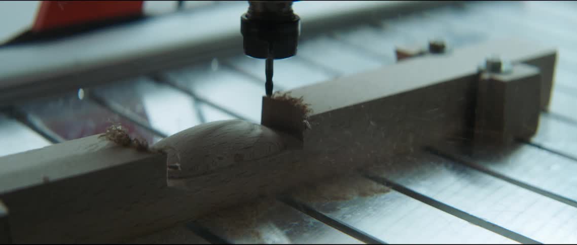 Power tool carves wood section spraying dust into air