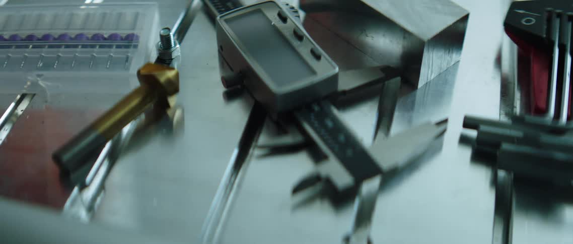Tools including wrenches and a level measuring device are laid out on a table