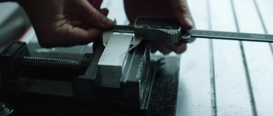 A person uses a tool to take a measurement