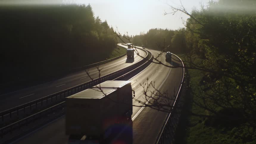 Cars and shipping trucks driving down a highway
