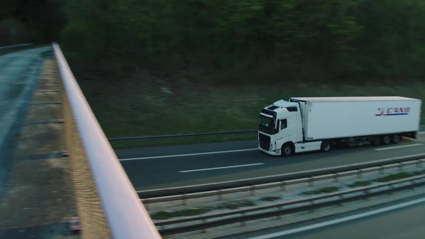 Shipping truck driving down the highway at sunrise