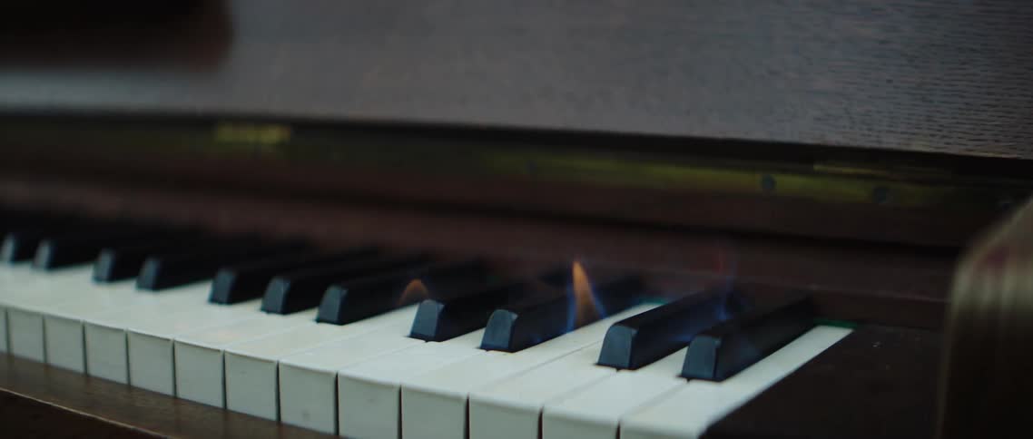 A piano with the piano keys on fire