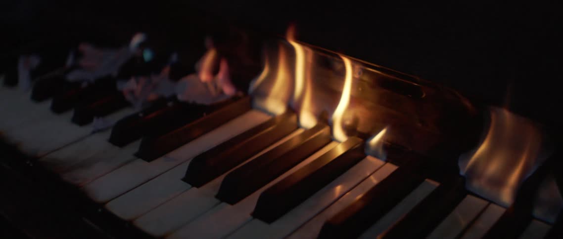 Flames burning the keys of a piano