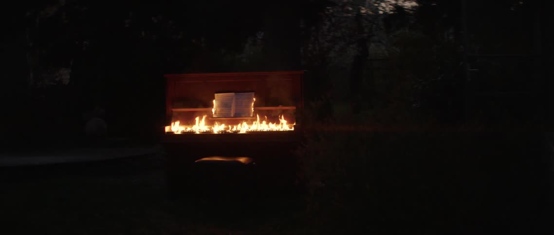 Piano burns outdoors in the dark night