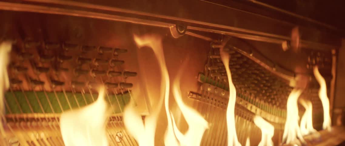Interior piano keys of upright piano engulfed in flames