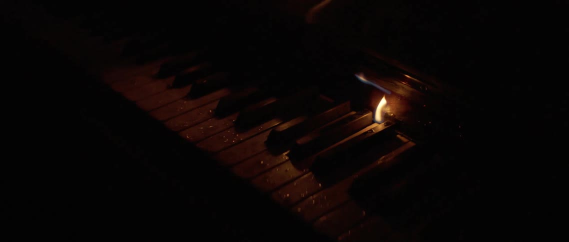 Flames arise between keys of a piano