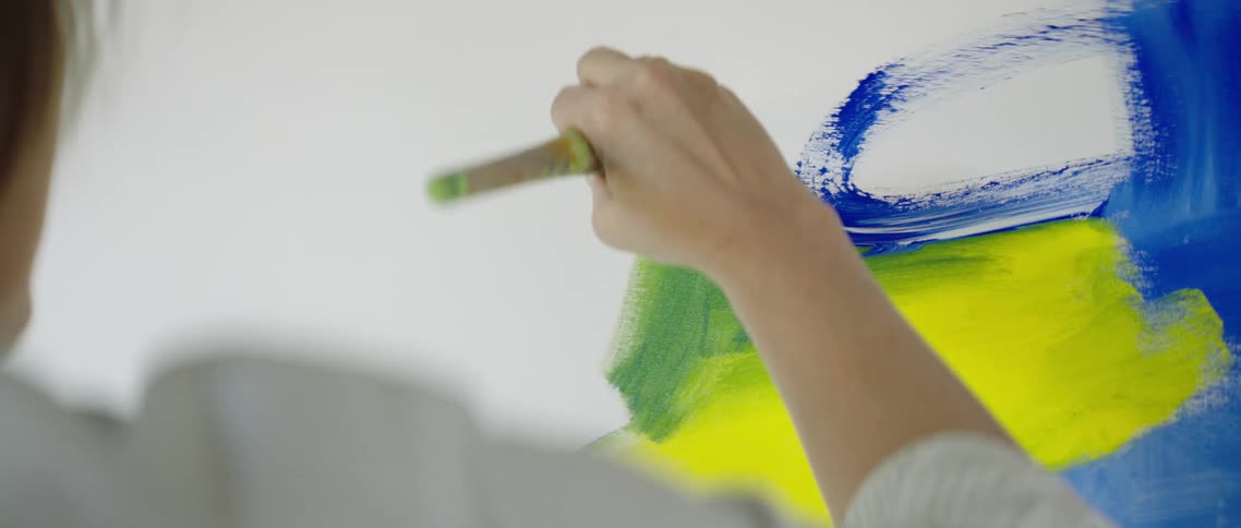 A woman paints on a canvas