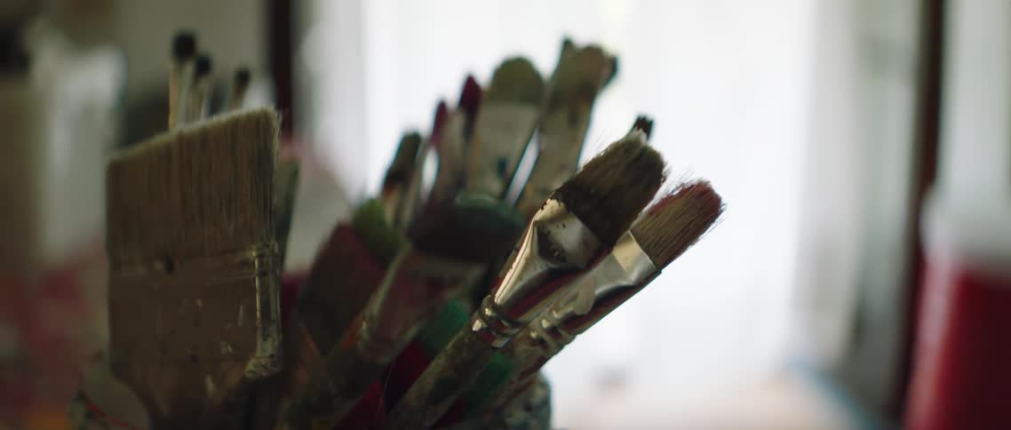 Various paint brushes sitting with the bristles pointing up