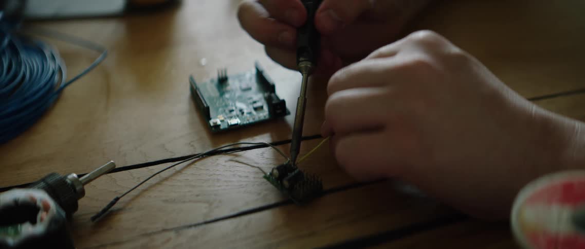 A man works on an electrical device and it smokes