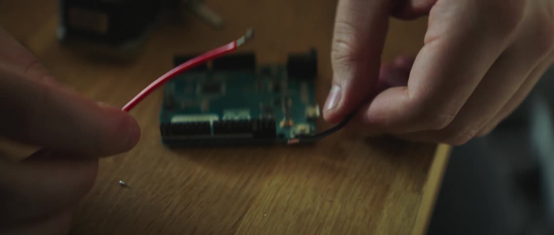 A man cautiously puts two wires together and they spark