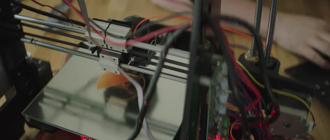 The arm of a 3d printer sliding back and forth as it prints an object