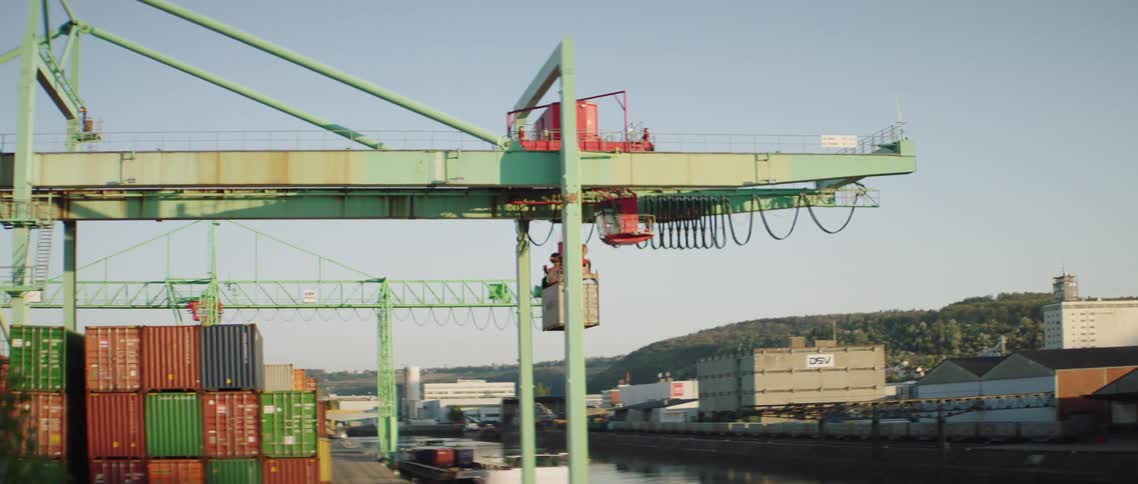 A machine carries a shipping container