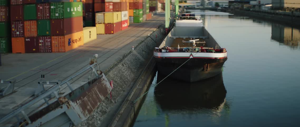 Shipping containers on a dock with a boat in the water