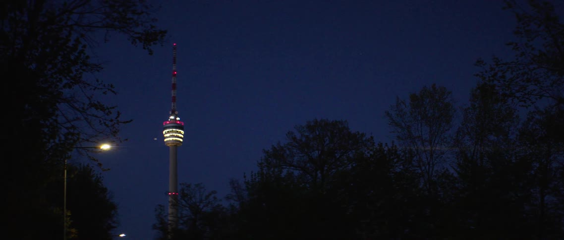 A large needle structure with an antenna on top at night