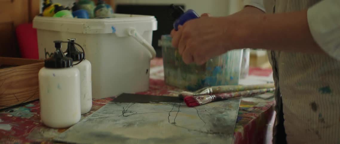The artist adds paint to the canvas