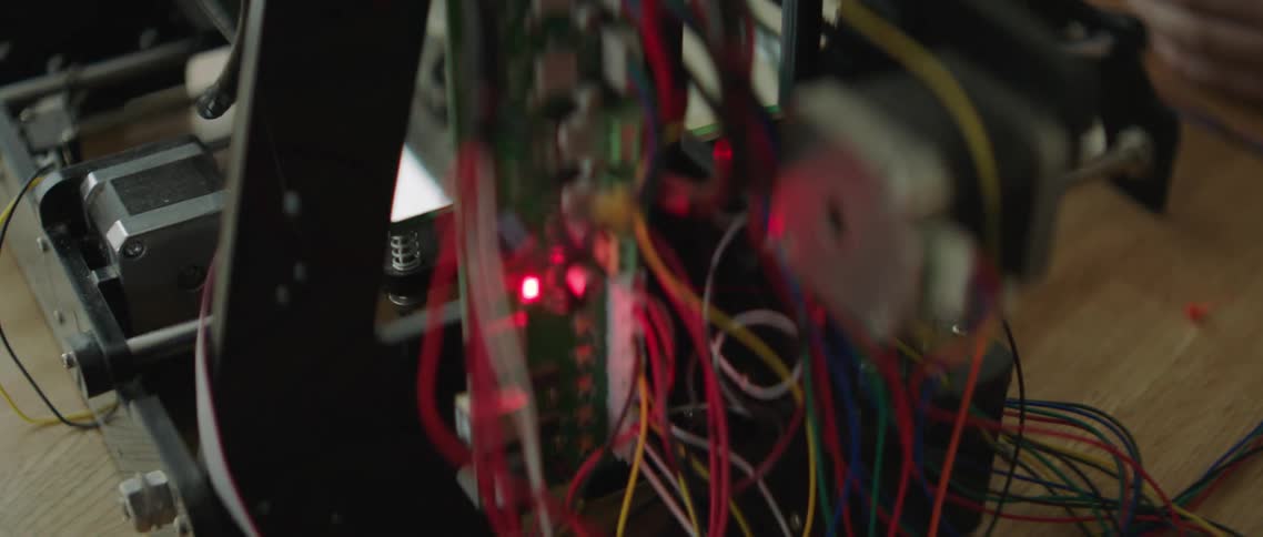 A white person touches a finger to wiring in an electronic system