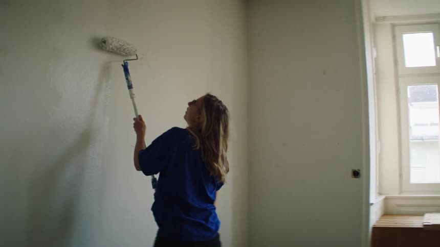 A woman paints inside her house
