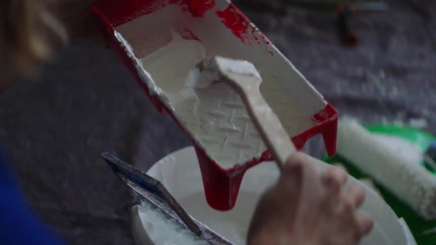 A woman puts paint on a paint brush