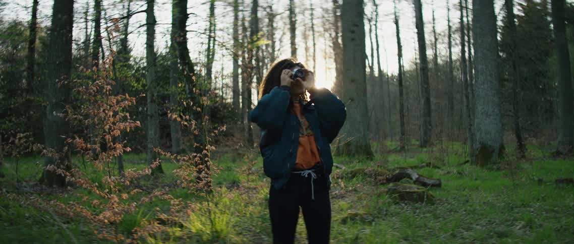 A woman takes photographs at sunrise