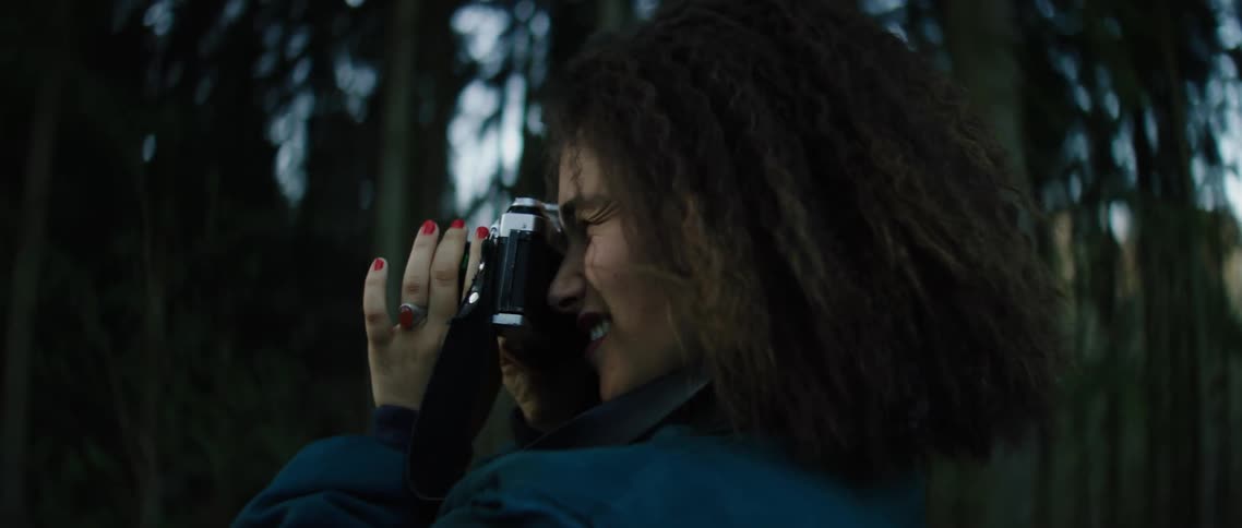 A woman takes photos in a forest