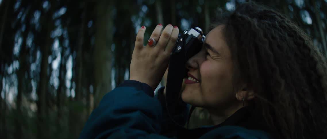 Female photographer takes pictures of trees outdoors