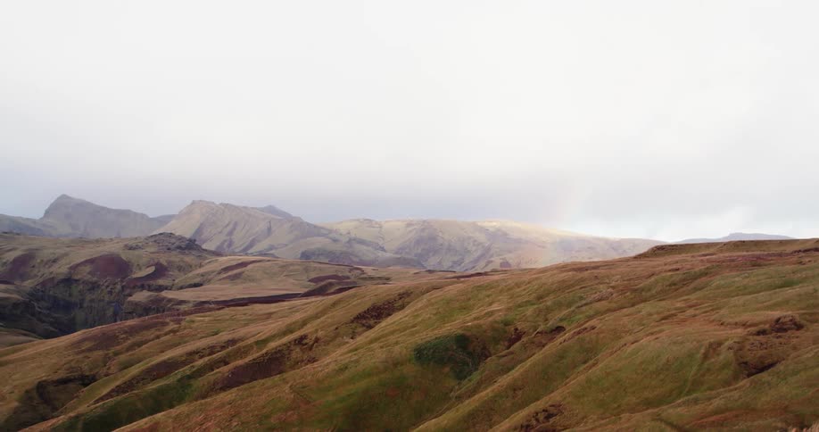 Brown hills dusted with green on a cloudy day