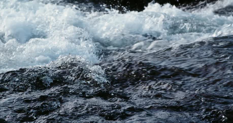 Water flowing on a river creates turbulence passing over rocks