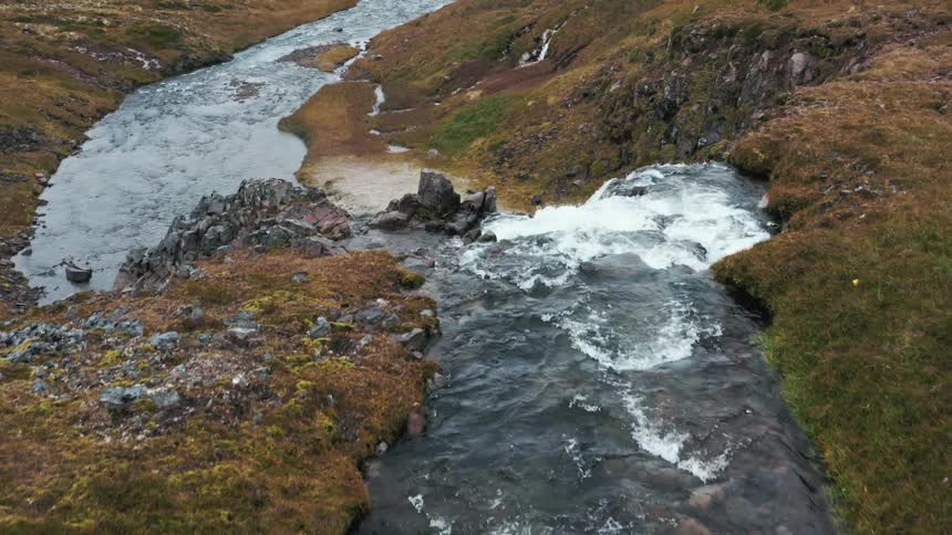 Fast flowing stream in highlands cascades over waterfall