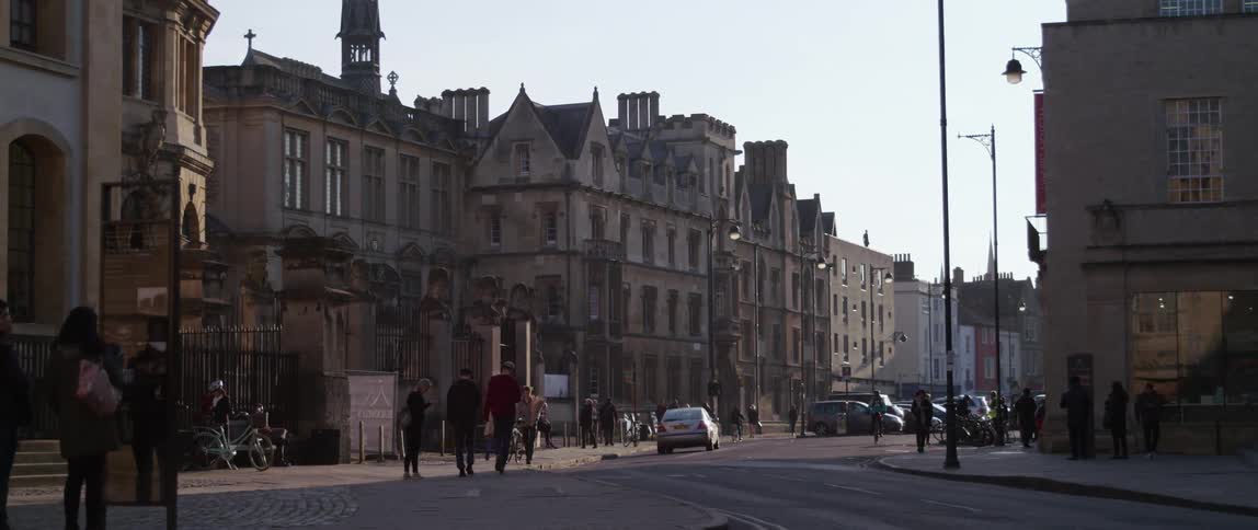 A street in Oxford with people vehicles and buildings