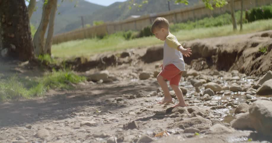 A child walks over the rocks on the field