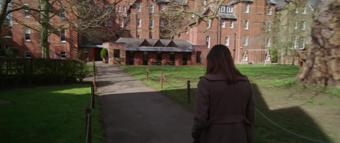 A woman walks across a campus