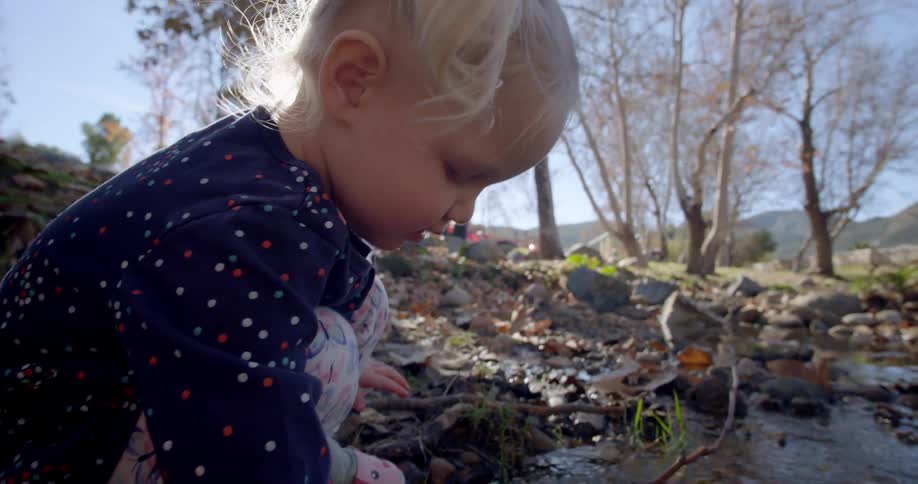 A child splashes in the water of the stream