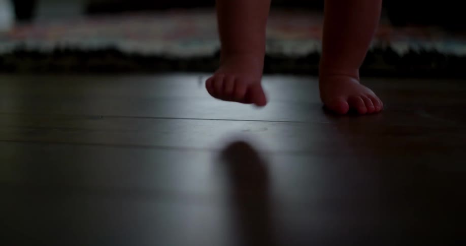 Baby feet walking across hardwood floor