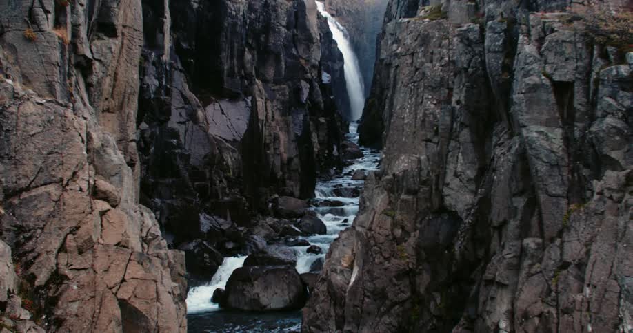 Waterfall flows into a stream which flows over the rocks in a canyon
