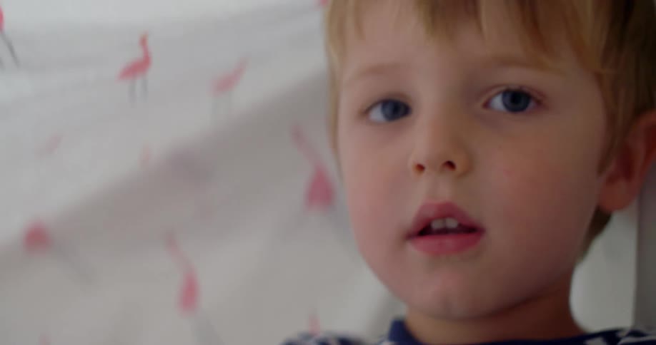 The child lifts the fabric over his head