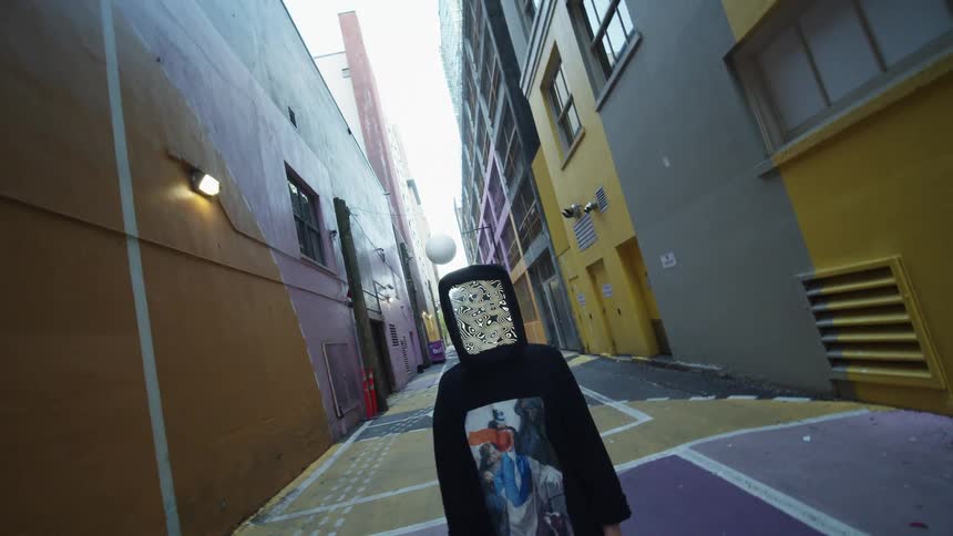 A person with a rectangle mask standing in an alleyway