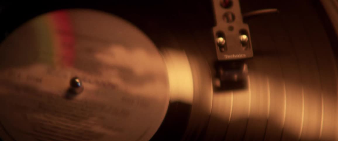 A record album spins slowly on a record player then spins faster
