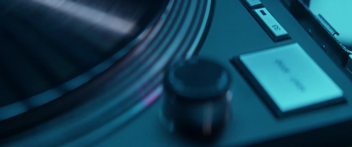 Record spins on turntable in dimly lit room