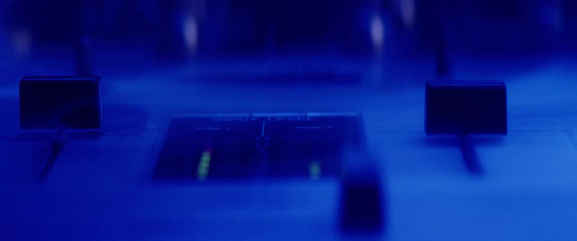 Extreme close up of audio mixing board equalizer with changing light colors and smoke