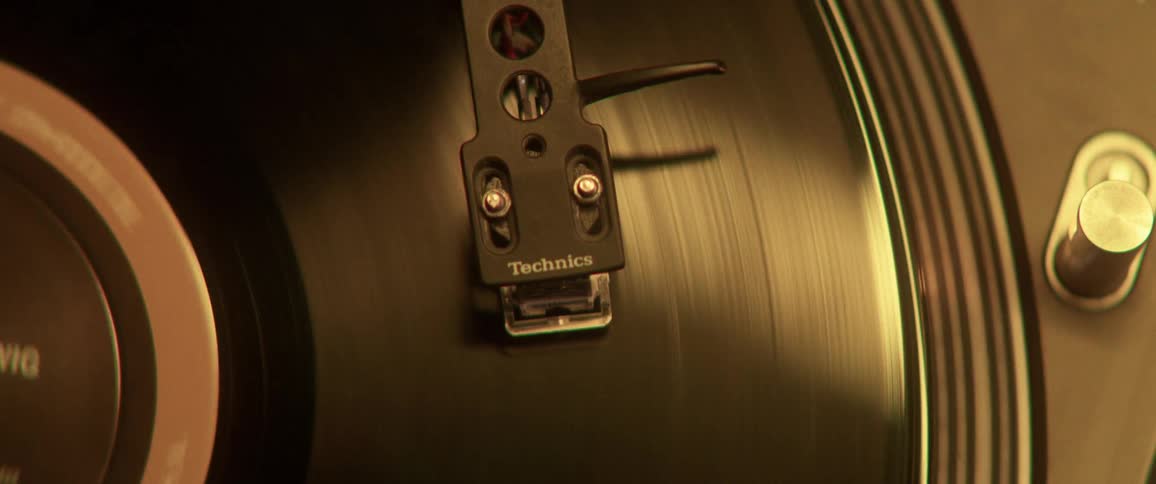 A person places a needle on the record
