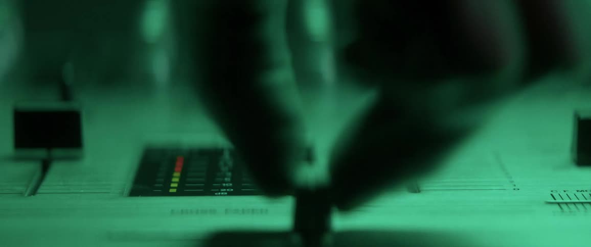 A persons hand moving a knob on a mixer